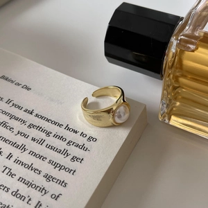 Elegant 18k gold plated S925 sterling silver open ring with a round pearl on a book