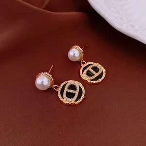 French vintage earrings with gold plating, zircon, and pearls on a silk background