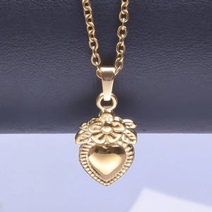 Macro shot of gold-plated 18k heart pendant with floral engraving and polished mirror finish