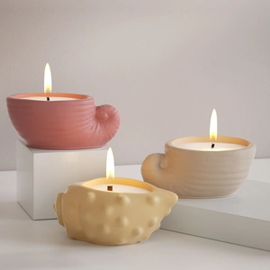 Detailweergave van de schelpvormige keramische kandelaars in pastelroze en beige