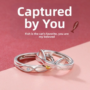 Detail of cat and fish themed couple rings with gold heart and wave patterns