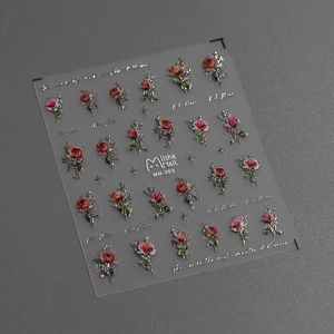 Macro detail of 3D embossed red rose and silver star nail stickers on dark grey background