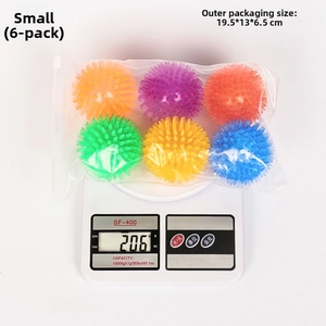 Detail view of colorful TPR spike squeaky dog balls on scale showing weight and size