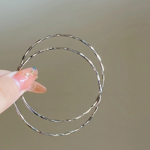 Macro shot of silver-toned textured hoop earrings showcasing metallic circular design