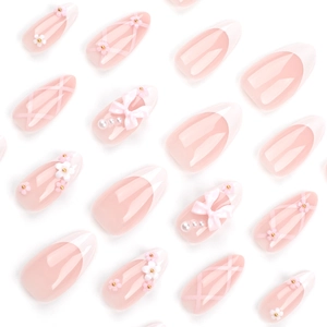 Pink and white French press-on nails with 3D bows, pearls, and floral accents