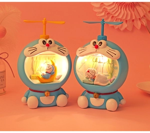 Detailed close-up of Doraemon night lights with warm glow on a soft pink background