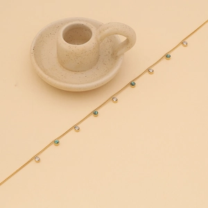 Detail of gold chain necklace with turquoise beads and clear droplet pendants