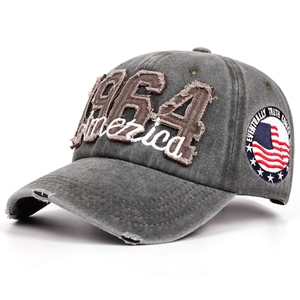 Detail view of washed grey baseball cap with 1964 embroidery and distressed torn effects