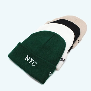 Detailed view of NYC and 1998 embroidery on multiple colored knitted beanies