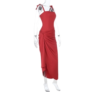 Détail de la robe rouge fendue élégante avec taille froncée et tissu satiné drapé