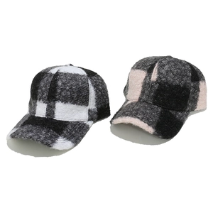 Detailed view of winter checkered baseball caps in black-white and pink-black tweed fabric