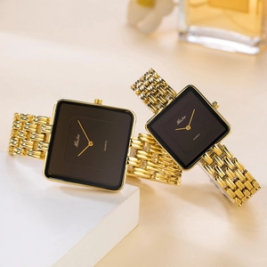 Detail view of two gold square watches with black dials and luxury metal bands