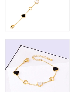 Detail of gold heart bracelet featuring black and white shell charms and adjustable clasp