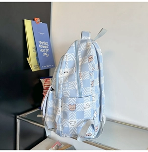 Close-up of cute bear and rabbit patterns on a blue checkered canvas backpack side view