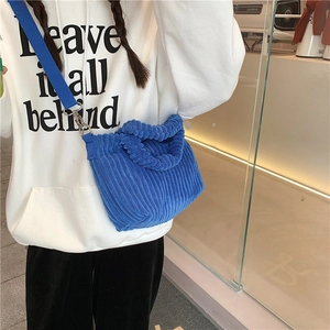 Détail du sac bandoulière en velours côtelé bleu avec sangle large et finition texturée