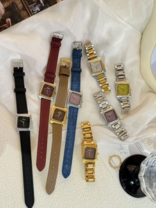 Vue à plat de montres à quartz carrées avec bracelets en cuir et acier sur soie blanche