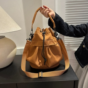 Détail du sac seau en nylon camel avec fermeture à cordon et boucles en métal