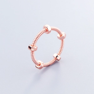 Detailed view of rose gold screw nut ring with unique threaded industrial design