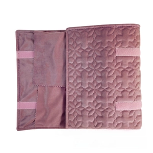 Detail view of purple velvet jewelry roll with quilted floral pattern and interior storage pockets