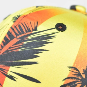 Macro detail of tropical palm tree print on vibrant gradient fabric with black eyelet