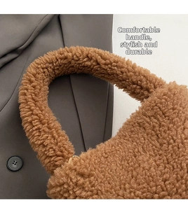 Detail of soft brown plush teddy fur handbag with rounded handle and gold hardware
