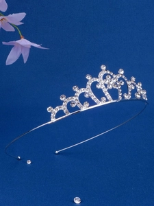 Close-up of silver crown headband with heart shaped rhinestones on a blue background