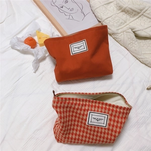 Detail of orange and houndstooth canvas makeup bags with Time to Party labels