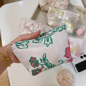 Close-up of vintage floral jacquard mini pouches with rose embroidery and gold zippers