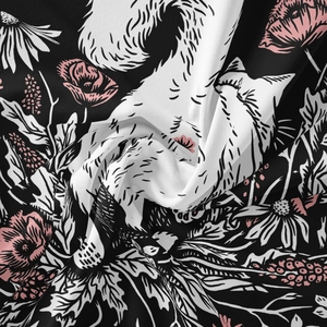 Detail shot of cat and floral print fabric showing woven texture and soft drape folds