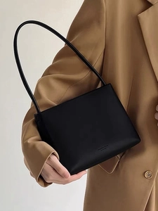 Elegant black leather rectangular shoulder bag worn over a camel blazer for women