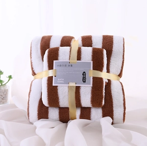 Detailed close-up of brown striped coral fleece towel set with decorative gold ribbon