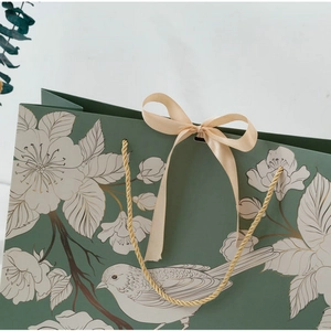 Dark green gift paper bag with gold floral bird patterns and champagne silk ribbon bow