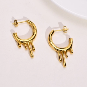 Macro detail of irregular C-shaped flowing water drop earrings in polished gold finish