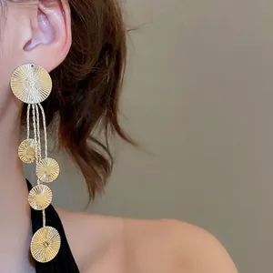 Gold tassel drop earrings with five sunburst engraved metal circles in minimalist design