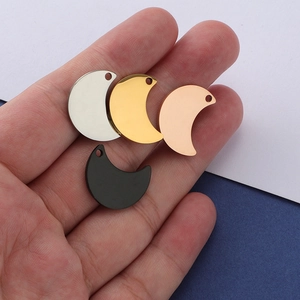 Polished stainless steel crescent moon charms in four colors held for scale comparison