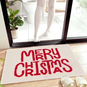 Close-up of thick faux cashmere Christmas mat texture with red lettering on wood floor
