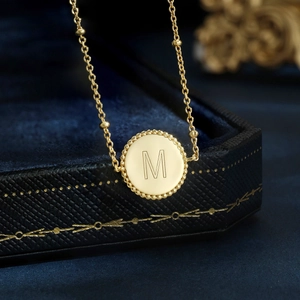 Elegant gold S925 sterling silver necklace with a round letter M pendant and beaded edge