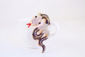 Close-up of golden snake keychain with white rhinestones and black enamel scales