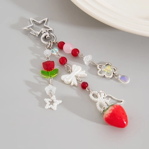 Dettaglio portachiavi con ciondolo a fragola, fiore tulipano e chiusura a stella su grigio