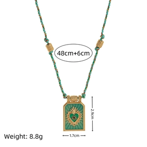 Gold-plated tarot heart necklace with green enamel on a colorful braided cord chain