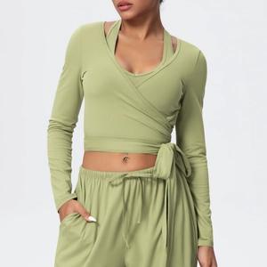 Detail of avocado green V-neck wrap yoga top with cross strap design and soft texture