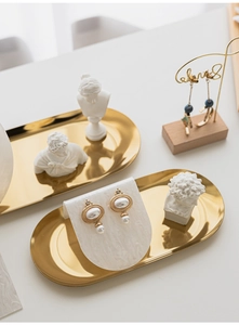 Macro shot of vintage pearl earrings displayed on marble acrylic stand with gold accents