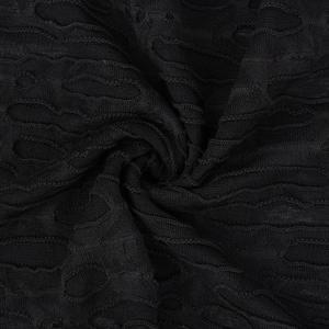Dettaglio del tessuto a maglia nera con trame artistiche traforate e design usurato