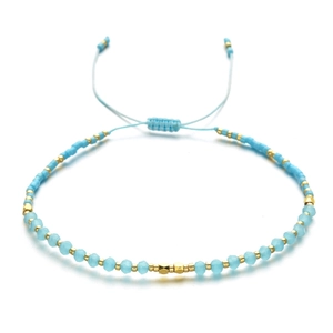 Detail eines verstellbaren Boho-Armbands mit himmelblauen Kristallperlen und Goldakzenten