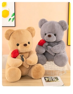 Primer plano de ositos de peluche marrones y grises con rosas rojas y lazos de lunares