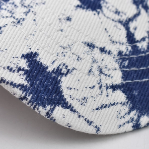 Detailaufnahme des blauem Tintenspritzer-Musters auf weißem Baumwoll-Baseballcap