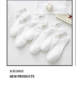 Detail view of six pairs of white low-cut socks with cute animal embroidery on white background