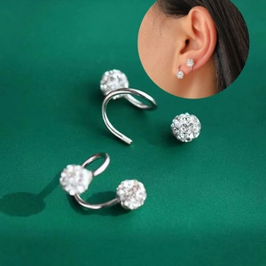 Minimalist silver screw earrings with double shimmering crystals on green background