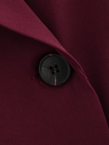 Dettaglio macro del blazer bordeaux con tessuto saia e bottone marmorizzato