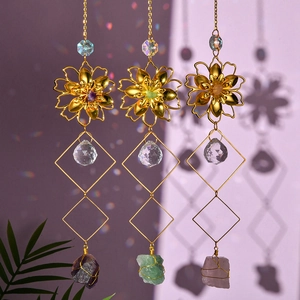 Three gold metal flower suncatchers with natural raw crystals and rainbow light shadows